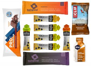 Image of various gels and bars used for fueling (Pro Bar, SiS gels, Gu, Clif Bar, Tailwind Endurance Fuel, Tailwind Recovery Mix).